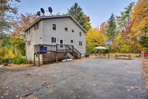 a large white barn with a porch and a picnic table at Pet-Friendly Gilford Home 3 Mi to Gunstock and Lake in Gilford