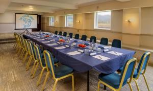 una sala de conferencias con una mesa larga y sillas en Macdonald Tickled Trout Hotel, en Preston