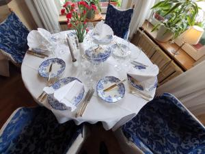 una mesa con platos azules y blancos y gafas. en Royal Hotel-Restaurant Bonhomme, en Sougné-Remouchamps