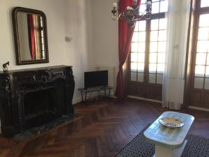 a living room with a fireplace and a mirror at Résidence du Château in Jonzac