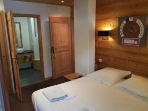 Dormitorio pequeño con cama y espejo en Le calme, le confort, la nature, skis aux pieds, à 15 kilomètres de Chamonix en Vallorcine