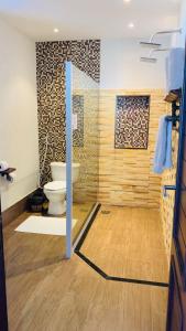 a bathroom with a toilet and a glass door at Hotel Santuário das Águias in Aquiraz