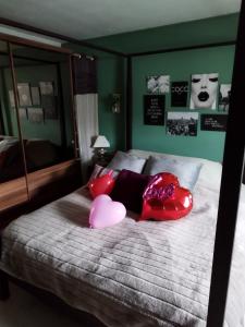 sypialnia z łóżkiem z różowymi poduszkami w obiekcie Maison d hôtes Les Notes Endormies " Suite La Mystérieuse" w mieście Berzée