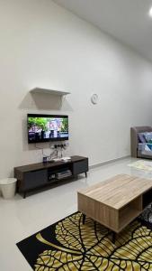 - un salon avec une télévision et une table basse dans l'établissement Yuyu Star Suites, à Kampong Bekoh
