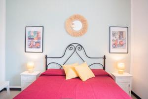 a bedroom with a bed with a red bedspread at Vespa Apartments in Moneglia