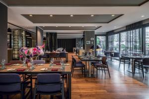 un restaurant avec des tables, des chaises et des fenêtres dans l'établissement Sheraton Zürich Hotel, à Zurich