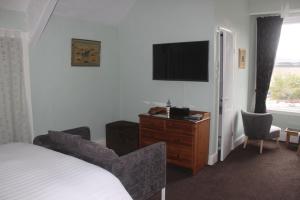 a hotel room with a bed and a television at Hazeldene Guest House in Bowness-on-Windermere