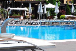una gran piscina con sillas y sombrillas en Studio Militari Residence MR_1, en Roşu
