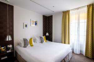 Postel nebo postele na pokoji v ubytování Hôtel Le Colisée