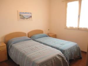 2 nebeneinander sitzende Betten in einem Schlafzimmer in der Unterkunft Appartamento Vigna del Mar in Lido