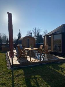 a wooden deck with a table and chairs in a yard at Yary Yurt in Všeruby