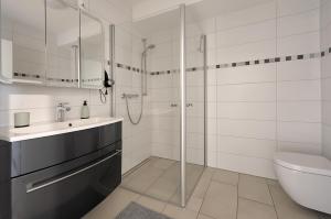 a bathroom with a shower and a sink and a toilet at Modern Wohnen I Smart TV I Terrasse I 2x Parkplatz I 2 Schlafzimmer I 6 Schlafplätze in Bad Oeynhausen +15 photos