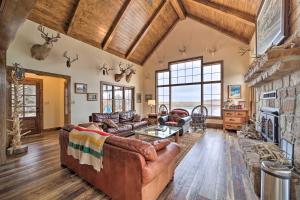 a living room with leather furniture and a stone wall at Lakefront Cedar Vale Lodge with Private Boat Dock! in Cedar Vale