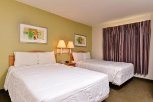 a hotel room with two beds and a window at Americas Best Value Inn & Suites-Winnie in Winnie