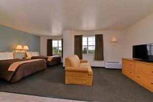 Habitación de hotel con 2 camas y TV de pantalla plana. en Americas Best Value Inn & Suites-Winnie, en Winnie