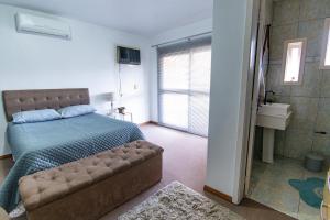 - une chambre avec un lit et une salle de bains pourvue d'un lavabo dans l'établissement Casa grande e aconchegante, à Encantado
