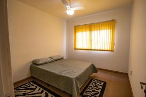 - une petite chambre avec un lit et une fenêtre dans l'établissement Casa grande e aconchegante, à Encantado