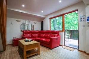 a living room with a red couch and a table at Lodge Nine - A Beautiful Holiday Home in Devon in Chudleigh