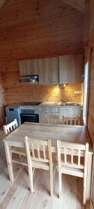 a kitchen with a large wooden table and chairs at Les Chalets de La Vialette in Servières-le-Château