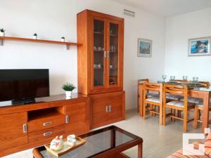 ein Wohnzimmer mit einem Entertainment-Center und einem Flachbild-TV in der Unterkunft Apartamento Apolo XVII 31 - Grupo Turis in Calpe