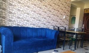 a living room with a blue couch and a table at Mombasa Shanzu One Bedroom Apartment /Swimming Pool/Free WiFi in Mombasa