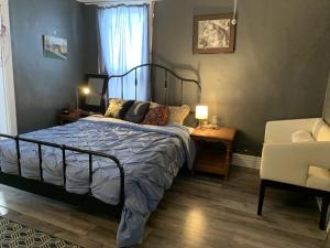 1 dormitorio con 1 cama y 1 silla en Maryland Homestay in Winnpeg downtown en Winnipeg