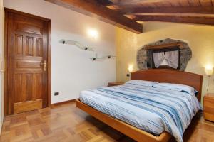 1 dormitorio con 1 cama y puerta de madera en La Mansarda di Eros e Tiziana, en Lanzo d'Intelvi