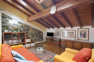 sala de estar con sofá y reloj en el techo en La Mansarda di Eros e Tiziana, en Lanzo d'Intelvi