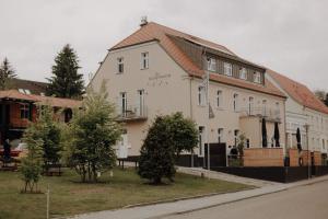 een wit gebouw met een bruin dak bij Klosterhotel Neuzelle in Neuzelle