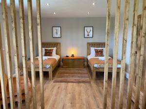 a bedroom with two beds and a table with a lamp at The Cart House in York