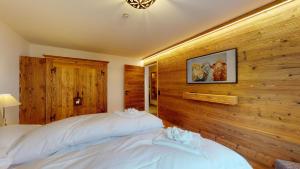 two beds in a bedroom with wood paneling at Abitaziun Munterots 6 1 - Silvaplana in Silvaplana