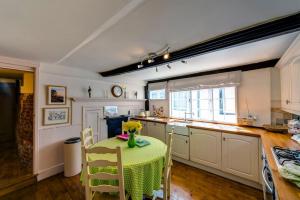 a kitchen with a table with a vase of flowers on it at Flushing House, Rye in Rye