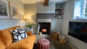 a living room with a couch and a fireplace at Jacks Cottage, Curbar in Curbar