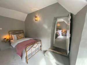 um pequeno quarto com uma cama e um espelho em Jacks Cottage, Curbar em Curbar