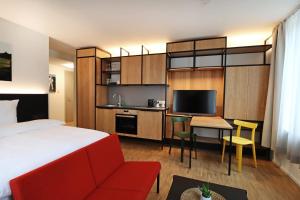 um quarto de hotel com uma cama, uma secretária e uma televisão em S12 - Boardinghouse by Hotel Trezor em Singen
