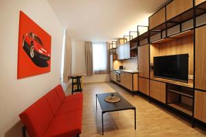 a living room with a red couch and a tv at S12 - Boardinghouse by Hotel Trezor in Singen