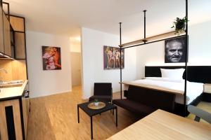 a bedroom with a large bed and a kitchen at S12 - Boardinghouse by Hotel Trezor in Singen