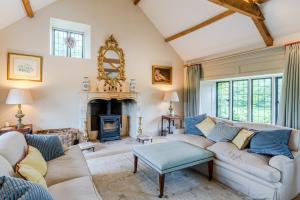 Una sala de estar con un sofá y una chimenea. en Grindstone Mill, en Alderley