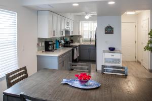 a kitchen with a table with a bowl of flowers on it at Island Club Turks & Grace Bay Place in Grace Bay