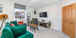 uma sala de estar com um sofá verde e uma mesa em Finest Retreats - Market View em Ripon