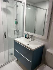 a bathroom with a sink and a shower with a mirror at BF Suites & Apartments in Porto