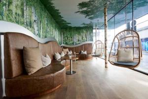 a room with a couch and a wall with a mural at Cocoon Stachus in Munich