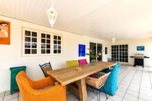 Sunny Palm Beach Villa في شاطئ بالم إيغل: غرفة طعام مع طاولة وكراسي خشبية