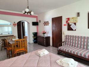 Habitación con cama, mesa y sofá en Apartamentos Campos 0 en Porto Covo