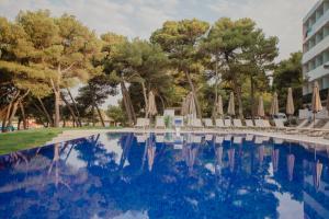 a pool at a hotel with chairs and umbrellas at Villa Arausa in Vodice +41 photos