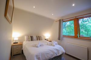 1 dormitorio con 1 cama con 2 toallas en Lodge Nine - A Beautiful Holiday Home in Devon en Chudleigh