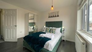 Un dormitorio con una cama grande y una ventana grande. en Fully Serviced Three Bed House in Durham, en Durham