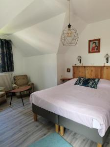 a bedroom with a large bed and a chair at Chez Yolande in Nothalten