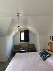 a bedroom with a white bed and a window at Chez Yolande in Nothalten