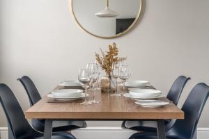 a dining room table with chairs and a mirror at Tudor House-Windermere Centre in Windermere